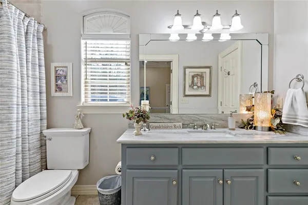 a bathroom with a sink vanity mirror and toilet