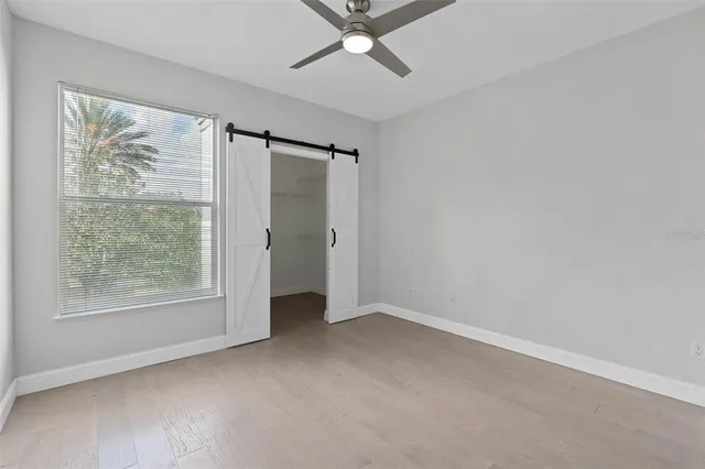 an empty room with a window and a ceiling fan