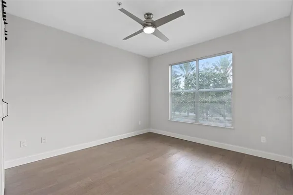an empty room with a window and a ceiling fan