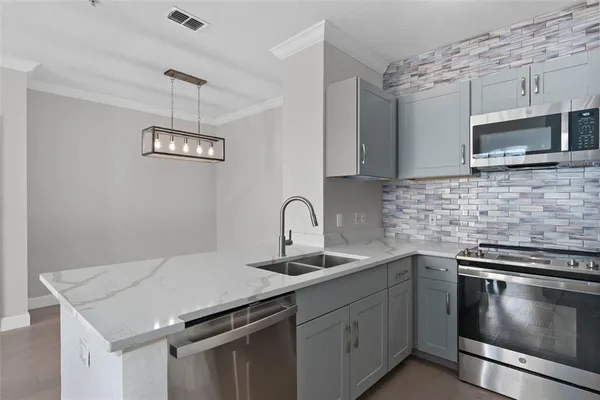 a kitchen with stainless steel appliances a microwave a stove and a microwave