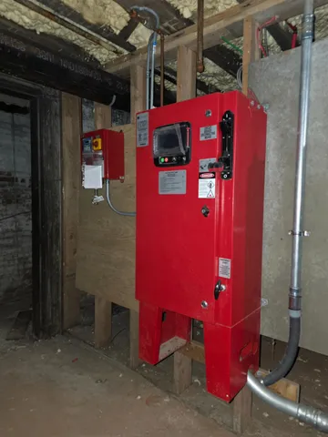 a room with exposed pipes and a window