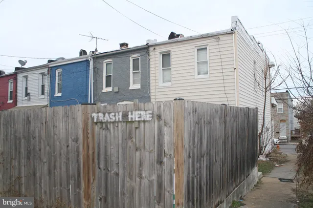 a view of an empty room with wooden floor and a ceiling fan