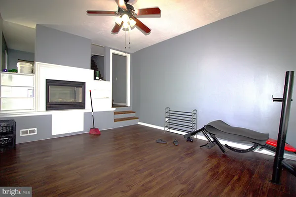 a living room with couches and kitchen view with wooden floor