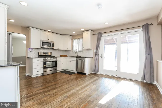 a kitchen with granite countertop white cabinets and stainless steel appliances