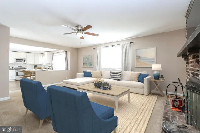 a living room with furniture a fireplace and a chandelier