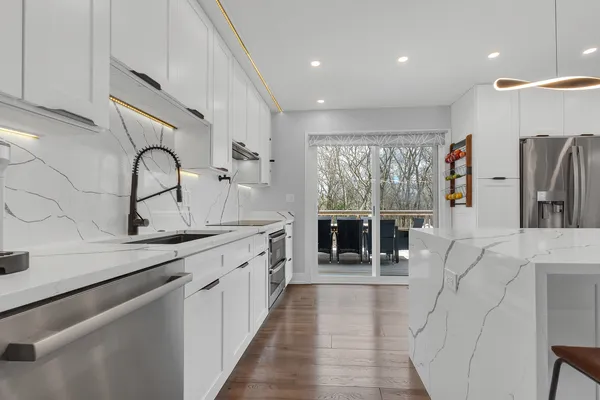 a kitchen with stainless steel appliances granite countertop a sink and a refrigerator