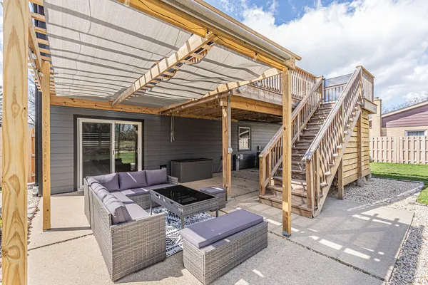 a patio with couches and a barbeque with wooden floor