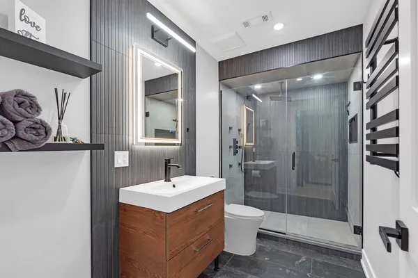 a bathroom with a sink mirror toilet and shower