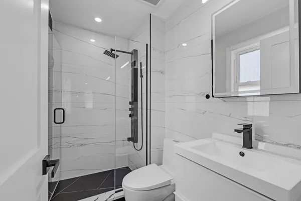 a bathroom with a sink a toilet and shower