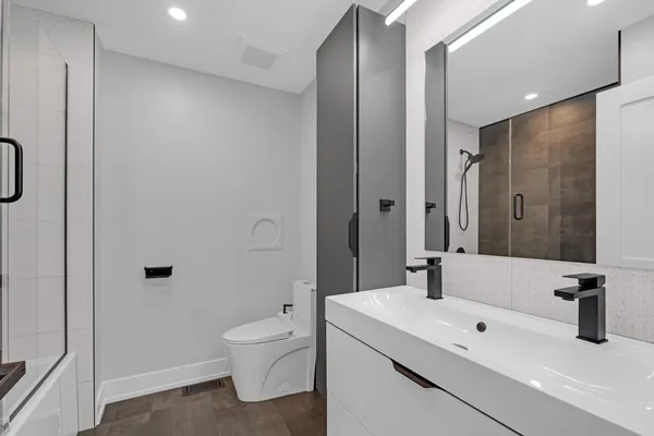 a bathroom with a granite countertop sink a toilet and shower