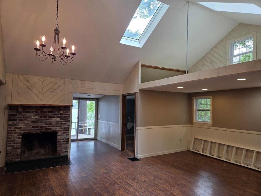 659 Reservoir Road Lunenburg, MA 01462 - Photo 13 of 41 a view of a livingroom with wooden floor a fireplace window and a kitchen