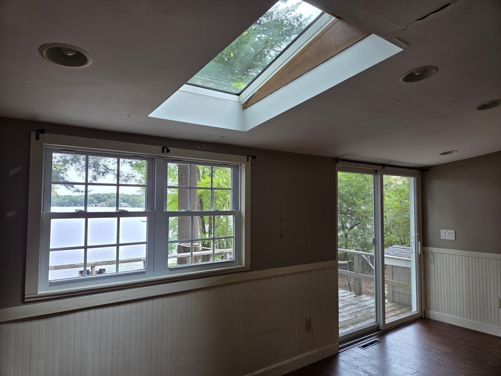 659 Reservoir Road Lunenburg, MA 01462 - Photo 16 of 41 an empty room with wooden floor and windows