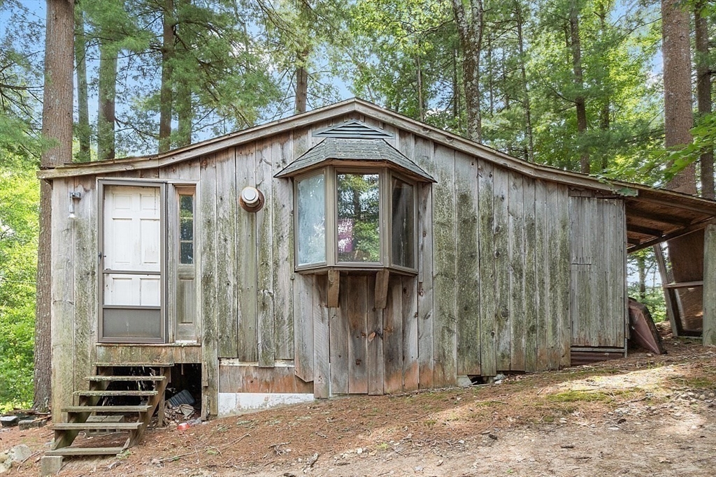 659 Reservoir Road Lunenburg, MA 01462 - Photo 27 of 41 a view of a house with large windows and a wooden fence