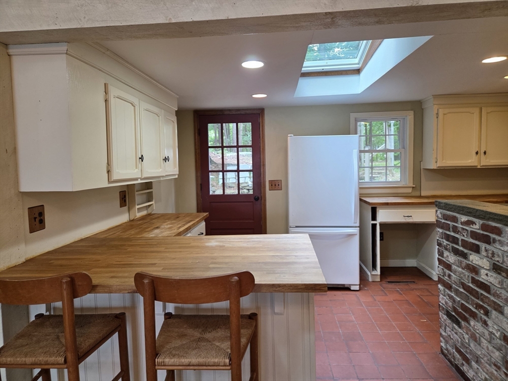 659 Reservoir Road Lunenburg, MA 01462 - Photo 8 of 41 a kitchen with granite countertop a stove a sink cabinets and wooden floor