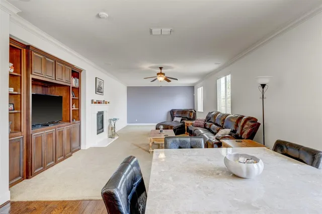 a living room with furniture a flat screen tv and a refrigerator