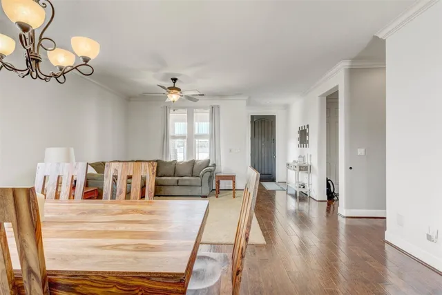 a living room with furniture a ceiling fan a lamp and a window