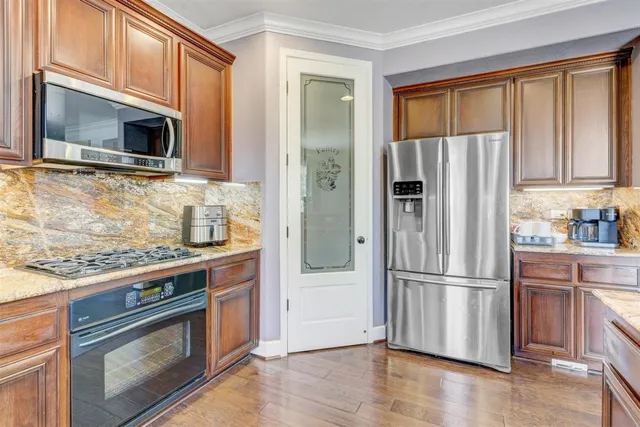 a kitchen with granite countertop a refrigerator stove and microwave