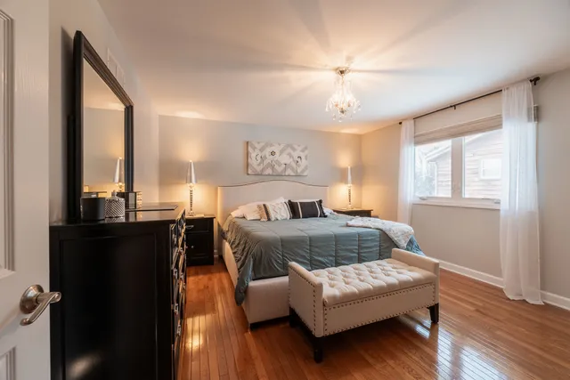 a bedroom with a bed window and wooden floor