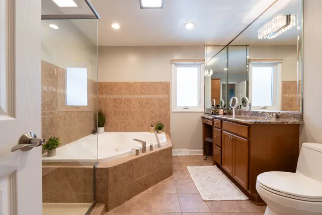 a bathroom with a bathtub shower sink mirror and toilet