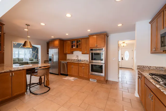 a kitchen with stainless steel appliances kitchen island granite countertop a sink and cabinets