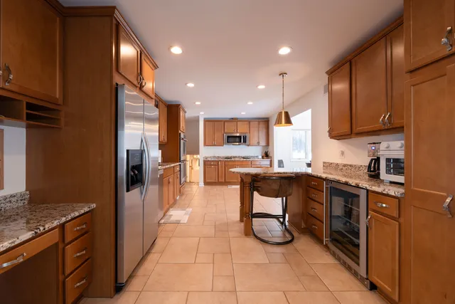 a kitchen with stainless steel appliances granite countertop a refrigerator and a stove top oven