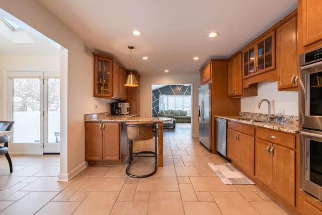 a kitchen with stainless steel appliances granite countertop a refrigerator and a sink
