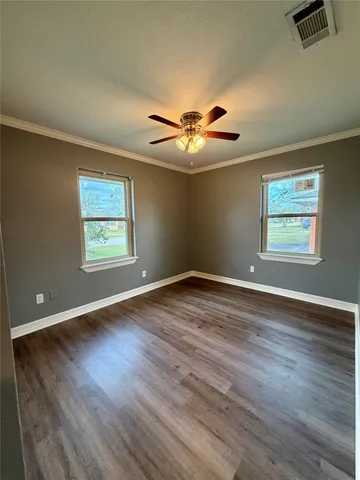 a view of a big room with wooden floor and a ceiling fan