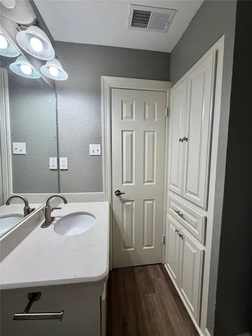 a bathroom with a sink a toilet a mirror and shower