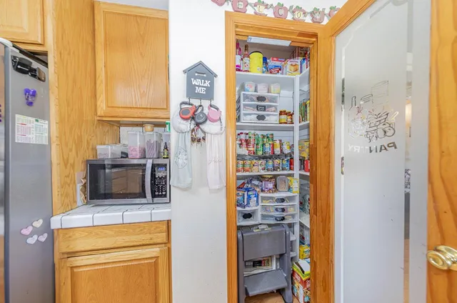 a kitchen with stainless steel appliances granite countertop a refrigerator a sink and a stove with wooden floor