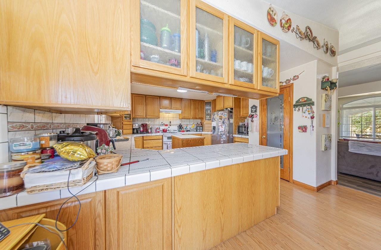 35095 Rough Rider Way Raymond, CA 93653 - Photo 22 of 57 a kitchen with stainless steel appliances granite countertop a refrigerator a sink and a stove with wooden floor
