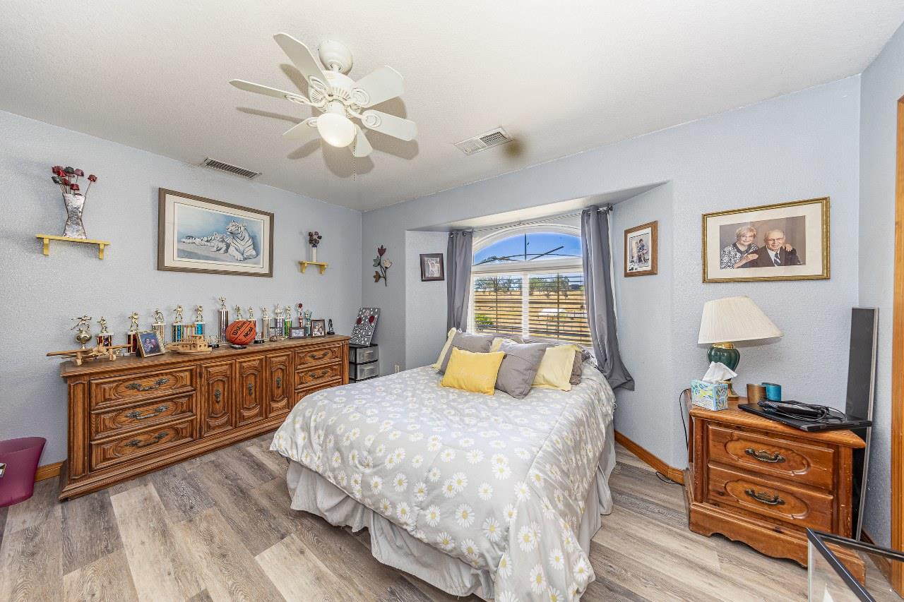 35095 Rough Rider Way Raymond, CA 93653 - Photo 28 of 57 a bedroom with a bed and wooden floor