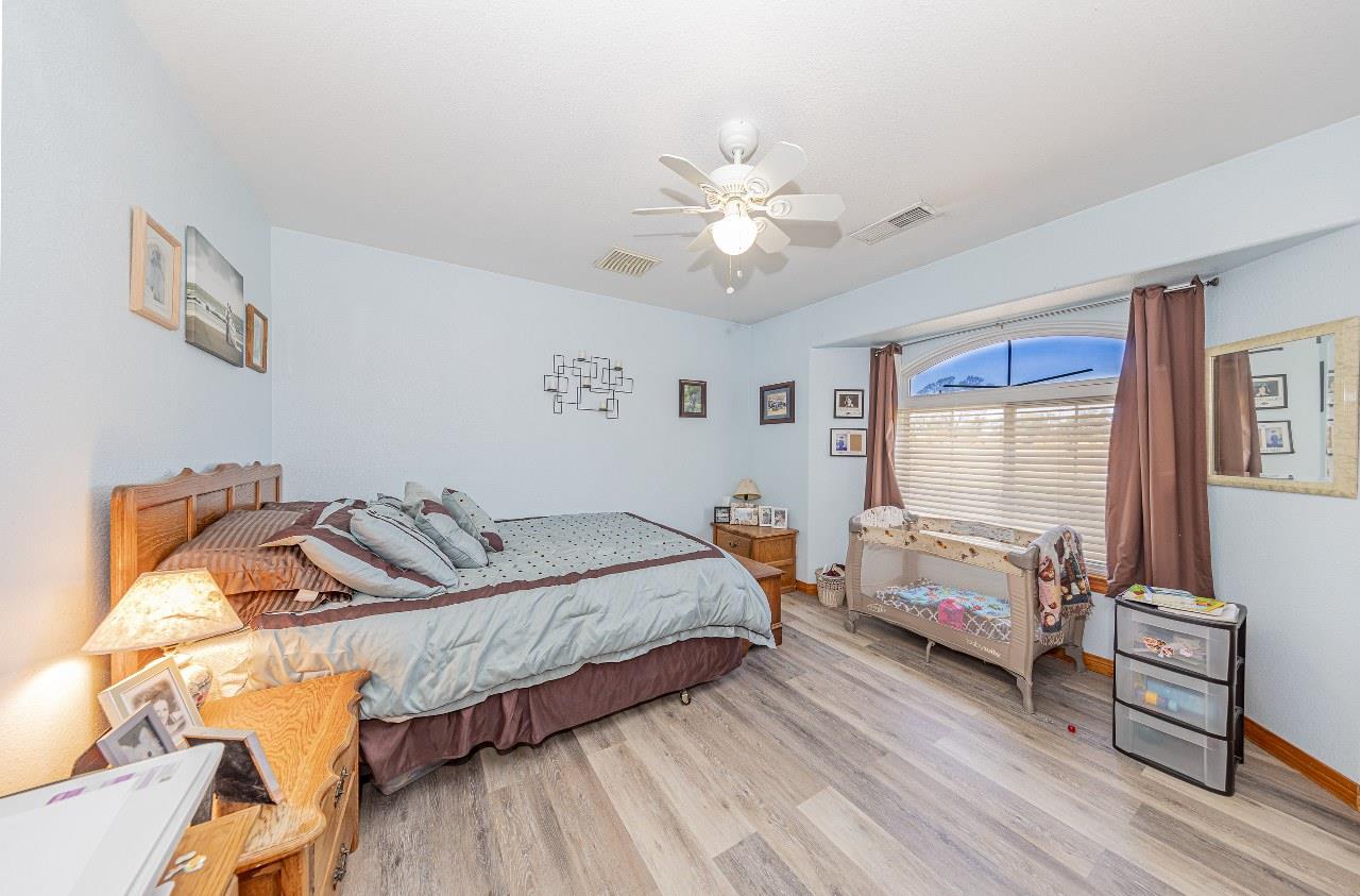 35095 Rough Rider Way Raymond, CA 93653 - Photo 31 of 57 a bedroom with a bed and wooden floor