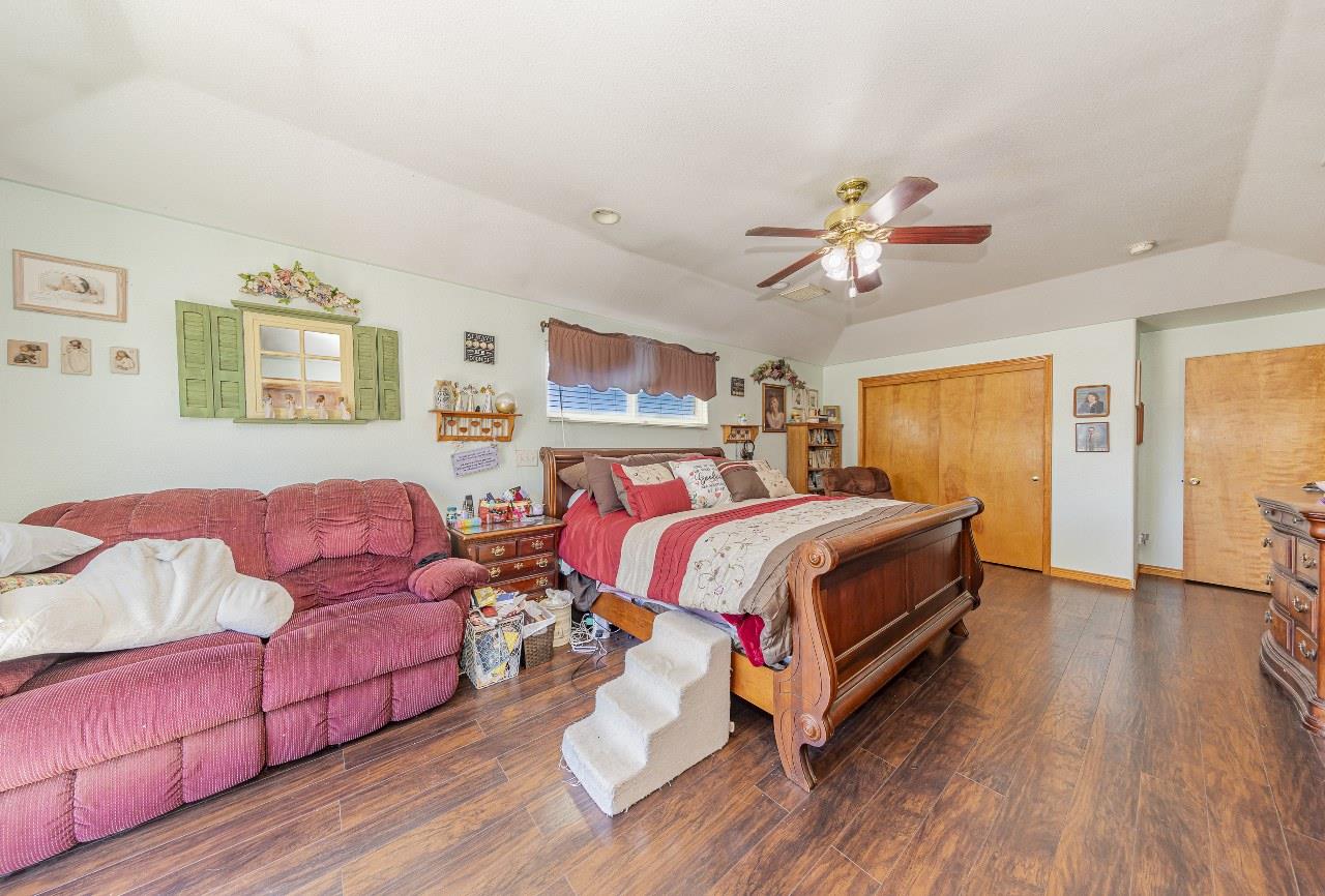 35095 Rough Rider Way Raymond, CA 93653 - Photo 34 of 57 a bedroom with a bed and wooden floor