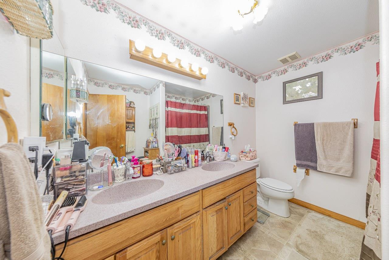 35095 Rough Rider Way Raymond, CA 93653 - Photo 36 of 57 a bathroom with a double vanity sink mirror and toilet