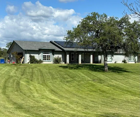 a front view of house with yard and green space