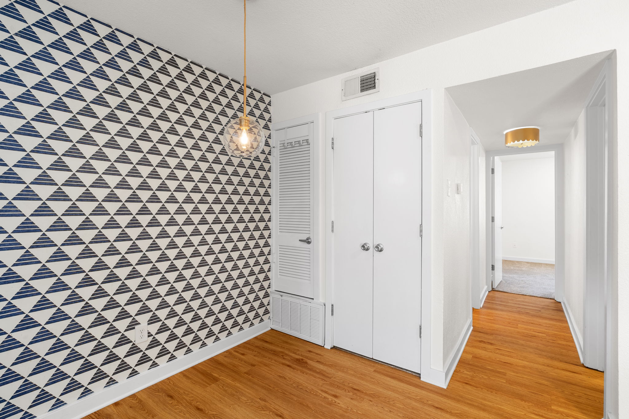 3601 Menchaca Road, Unit 110 Austin, TX 78704 - Photo 18 of 37 Bold geometric wallpaper and warm hardwood flooring define this inviting entry space.