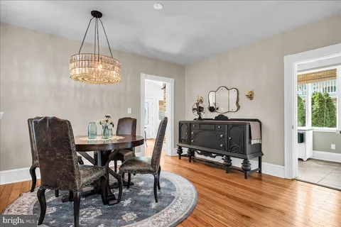 a dining room with furniture a chandelier and wooden floor