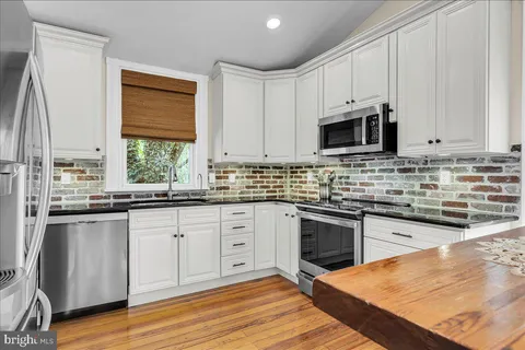 a kitchen with stainless steel appliances granite countertop a refrigerator sink and stove