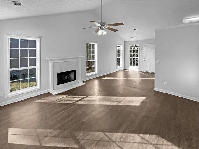 a view of a livingroom with wooden floor and a ceiling fan