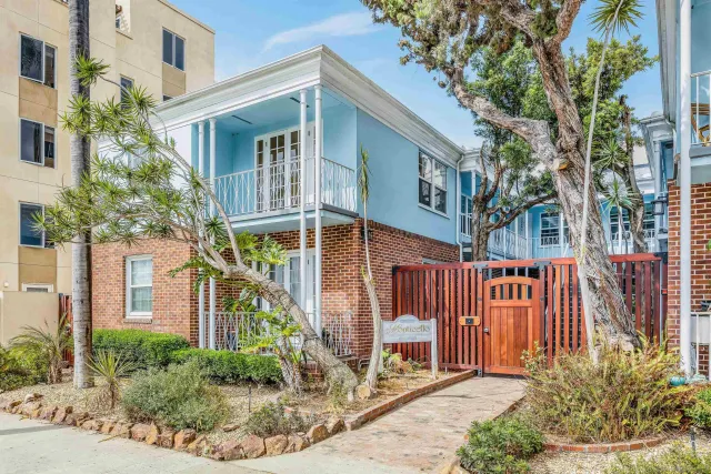 a front view of a house with glass windows and plants