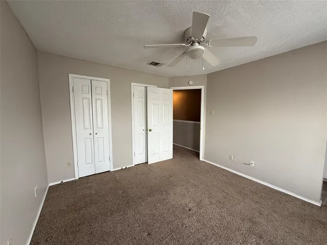 an empty room with fan and entrance
