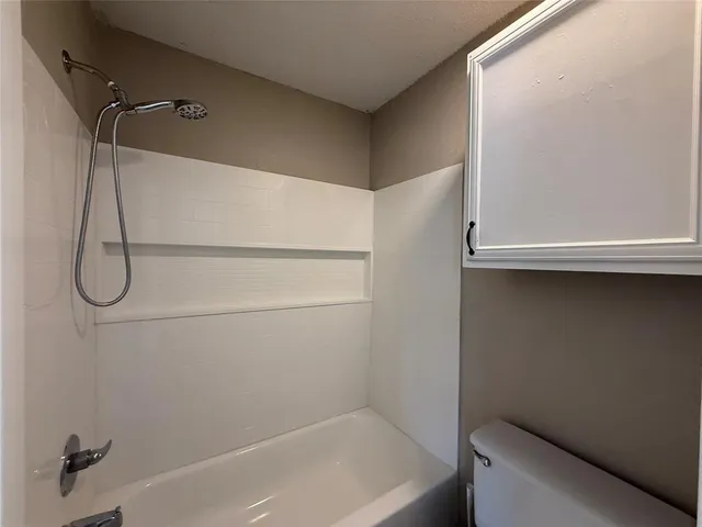 a bathroom with a bath tub with a shower