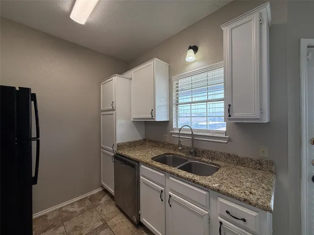 a kitchen that has a sink cabinets counter space and a window