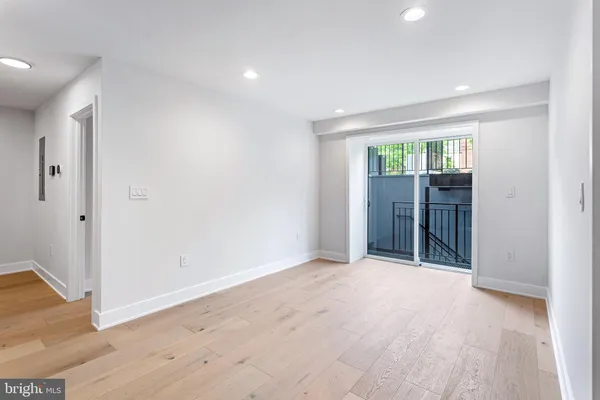 an empty room with wooden floor and a window