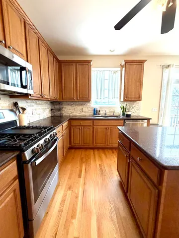 a kitchen with stainless steel appliances kitchen island granite countertop a sink and cabinets