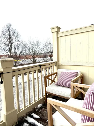 a view of a roof deck with couches and wooden floor