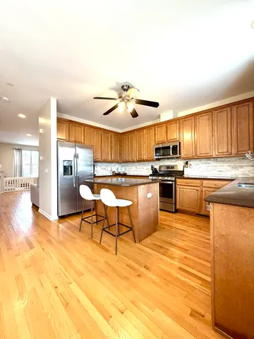a kitchen with stainless steel appliances granite countertop a stove a sink dishwasher and a refrigerator with cabinets