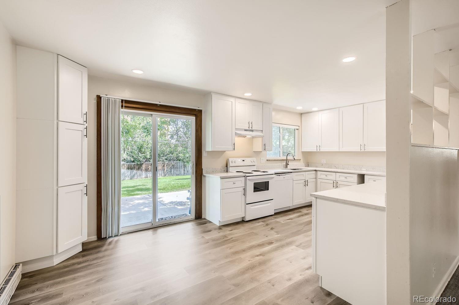 3205 Moorhead Avenue Boulder, CO 80305 - Photo 5 of 11 a kitchen with a stove top oven sink and white cabinets with wooden floor
