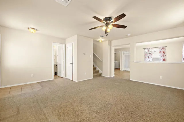 a view of a livingroom with a ceiling fan and window