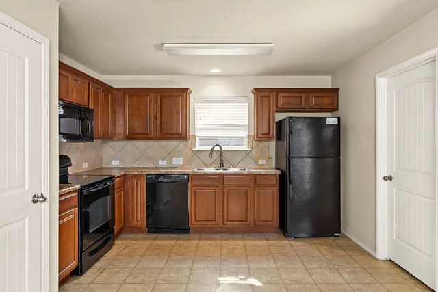 a kitchen with stainless steel appliances granite countertop a refrigerator and a stove top oven